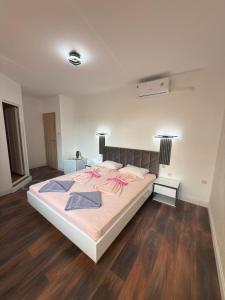 a bedroom with a bed with pink sheets and wood floors at M&D in Nesebar