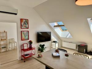 uma sala de estar com uma mesa e uma TV de tela plana em Meridian Bratislava - Stylish Brand New Apartment in the City Center & Free Garage Parking em Bratislava