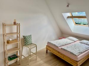 um pequeno quarto com uma cama e uma cadeira em Meridian Bratislava - Stylish Brand New Apartment in the City Center & Free Garage Parking em Bratislava