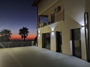 a building with a balcony with a sunset in the background at b&b TENUTE LAZZARINO in Sciacca