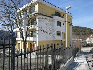 a yellow and white building next to a fence at Ваканционен Апартамент Делфин 10 Holiday apartment Dolphin 10 in Kavarna +10 photos