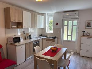 a kitchen with a table with a bowl of fruit on it at Apartments Silva in Split