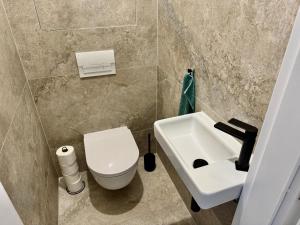 um banheiro com um vaso sanitário branco e uma pia em Meridian Bratislava - Stylish Brand New Apartment in the City Center & Free Garage Parking em Bratislava mais 13 fotografias