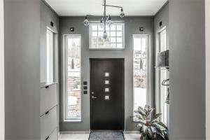 a hallway with a black door and windows at Island Villa in Sundsvall Alnö in Alnön