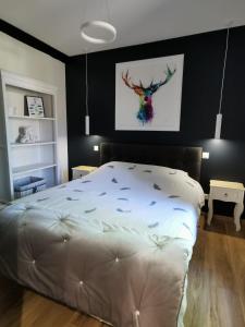 ChaonにあるLa Demeure du Faon Gite d elegance avec piscine et spa en plein coeur de la Sologne pres de Beauval et des Chateaux de la Loireの壁に絵が飾られたベッドのある寝室 +21枚の写真