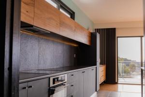 eine Küche mit Herd oberer Ofen neben einem Fenster in der Unterkunft The Cove Bay of Fires in Binalong Bay + 36 Fotos