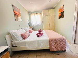 a bedroom with a bed with pink stuffed animals on it at Limnos Twin Pine in Néa Koútali
