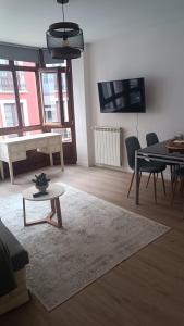 Una sala de estar con una mesa y un comedor. en Apartamento Galería Cine Colón, en Ribadeo