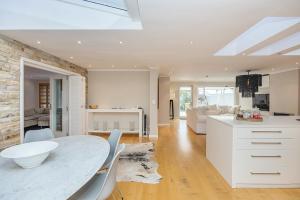a kitchen and living room with a white table and chairs at The Island Beach Villa in Cape Town
