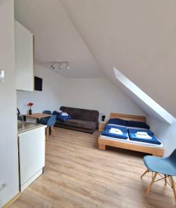 a living room with a bed and a kitchen at PokojeNaSpacerowej in Gąski