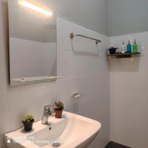 a white bathroom with a sink and a mirror at Ella Ceylonka in Ella
