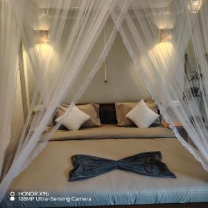a bedroom with a bed with a bow tie on it at Ella Ceylonka in Ella