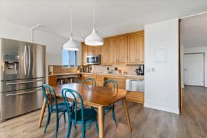 キヘイにあるBeautiful Oceanfront Condoの木製のテーブルと椅子のあるキッチン +5枚の写真