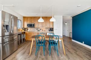 キヘイにあるBeautiful Oceanfront Condoのキッチン(木製テーブル、青い椅子付)