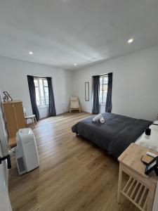 a bedroom with a large bed and a wooden floor at Suites Larios in Málaga