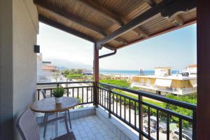 uma varanda com uma mesa e vista para o oceano em Manolas em Nei Poroi