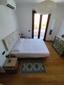 a bedroom with a large white bed and a table at Casa vacanze Brezza del Mar in Alghero +7 photos
