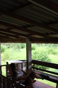 a woman sitting in a chair on a porch at Baan Yard Chumphon in Chumphon +10 photos