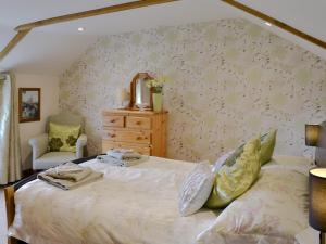 a bedroom with a bed with a dresser and a mirror at Gwel An Porth in Charlestown