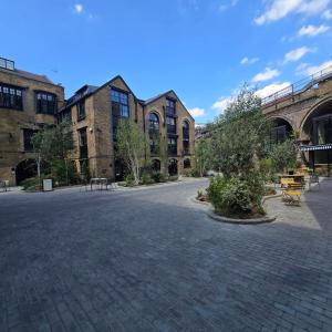 an empty courtyard in front of a large brick building at The Maltings Tower Bridge Apartment in London