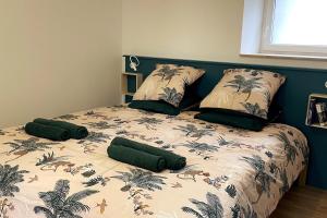 un lit avec quatre oreillers dessus dans une chambre dans l'établissement Bleiz Mor, à Brignogan-Plage