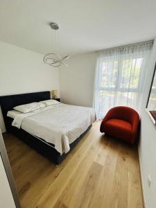 Un dormitorio con una cama y una silla roja. en Charming Apartment Mari Žnjan, en Split