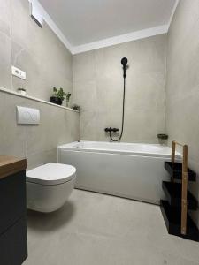 Un baño con bañera blanca y un inodoro. en Charming Apartment Mari Žnjan, en Split