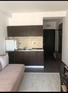 una cucina con armadi marroni e un divano in camera di Budva Studio a Kravlja