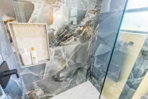 een badkamer met een glazen douchecabine met blauwe tegels bij Twin Pines Studios in Jacksonville +31 foto's