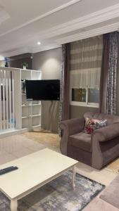 a living room with a couch and a flat screen tv at سكن ضيافة مفروش-ابها حي النزهة in Abha +16 photos