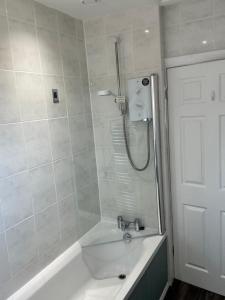 a white bathroom with a tub and a shower at Ash Cottage in Tollerton +13 photos
