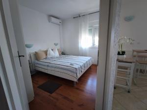 a bedroom with a bed and a table in it at Apartmani Jureta in Okrug Gornji