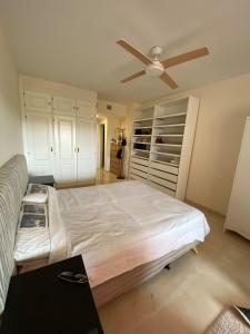 Un dormitorio con una cama y un ventilador de techo. en Duquesa Bella Vista - with pool and private garden, en Manilva