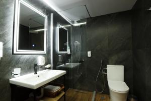 a bathroom with a sink and a toilet and a mirror at Rest & View Guesthouse in Gjirokastër +21 photos