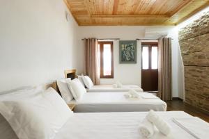 a room with three beds and a stone wall at Rest & View Guesthouse in Gjirokastër