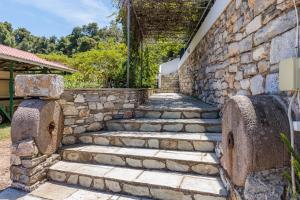 a stone retaining wall with stairs next to a building at Villa Mitsa in Kolios