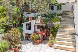a garden with a house with a fireplace and potted plants at Villa Mitsa in Kolios