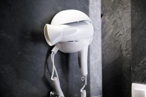 a white hair dryer hanging on a wall at Rest & View Guesthouse in Gjirokastër