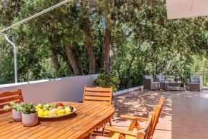 a wooden table with a bowl of fruit on a patio at Villa Mitsa in Kolios +36 photos