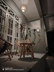 a room with a table and chairs and a potted plant at Ella Ceylonka in Ella