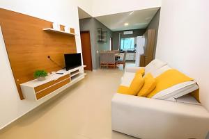 a living room with a white couch with yellow pillows at Linda Casa com 2quartos para 5 pessoas in Foz do Iguaçu