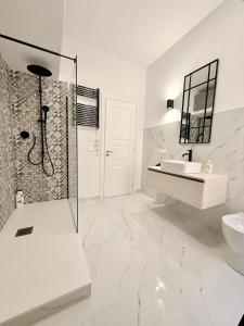 een witte badkamer met douche en wastafel bij La casa delle parole 2 in Agrigento +23 foto's