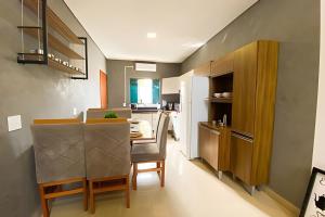 a kitchen with a table and a dining room at Linda Casa com 2quartos para 5 pessoas in Foz do Iguaçu