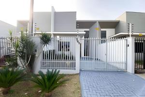 a white gate in front of a house at Linda Casa com 2quartos para 5 pessoas in Foz do Iguaçu