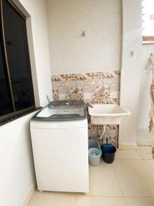 a white bathroom with a sink and a tub at Linda Casa com 2quartos para 5 pessoas in Foz do Iguaçu +15 photos