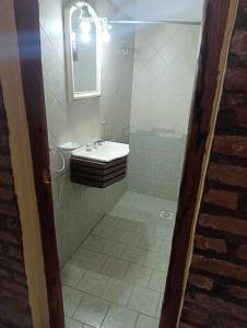 un bagno con lavandino e specchio di Cabañas Postal de la Villa a Villa Carlos Paz