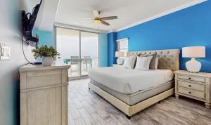 a bedroom with a bed and a blue wall at Gulf-Front Waterscape B401 Sundrenched in Fort Walton Beach +40 photos