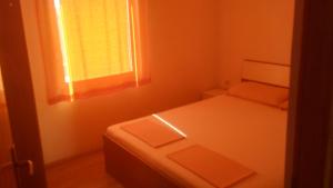 a small bedroom with a bed and a window at Apartmani Trputec, otok Vir in Vir