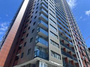 un grand immeuble avec un ciel bleu en arrière-plan dans l'établissement NBG Apartments, à Batoumi