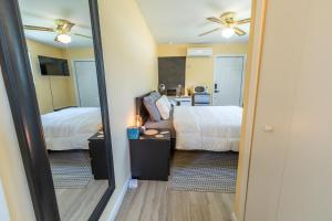 een hotelkamer met twee bedden en een spiegel bij Twin Pines Studios in Jacksonville